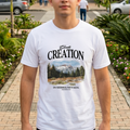 Joven posando en exteriores frente a un centro comercial vistiendo la camiseta blanca con diseño frontal God's Creation In Sierra Nevada de Trnd.Ink