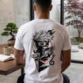 Hombre de espaldas en un ambiente zen con un bonsái, usando una camiseta blanca de trnd.ink con una ilustración artística detallada de Kakashi Hatake en la espalda.
