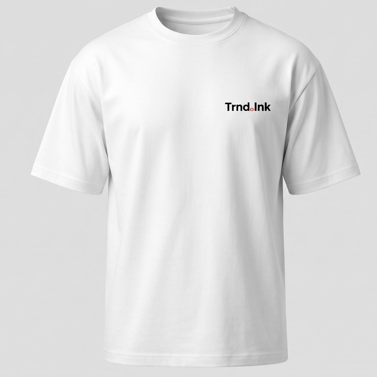 "Camiseta blanca de corte oversized con logo de Trnd.ink en el pecho, fondo gris neutro, estilo minimalista streetwear."
