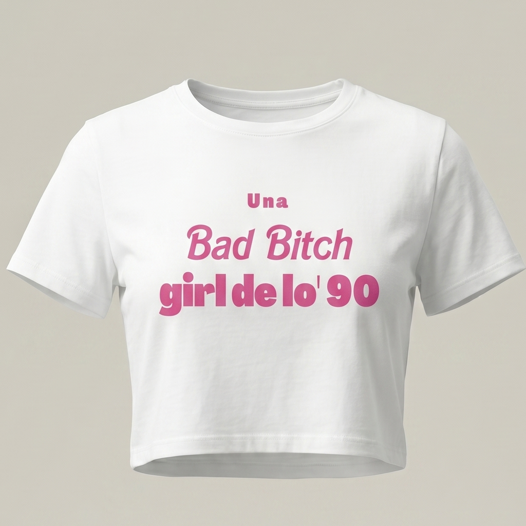 Camiseta blanca tipo crop top para mujer con estampado rosa que dice 'Una Bad Bitch Girl de lo' 90' sobre fondo neutro, estilo moda urbana retro.