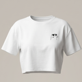 Maqueta de una camiseta blanca tipo crop top de manga corta con un estampado minimalista en color negro de un personaje con gafas de sol en la parte lateral del pecho, sobre un fondo neutro.