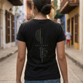 Mujer de espaldas caminando en una calle urbana usando la camiseta negra con diseño conceptual "Balance" de Trnd.ink.