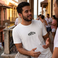 Hombre vistiendo camiseta blanca con diseño minimalista 'PERSPECTIVE' de la marca trnd.ink en un entorno urbano