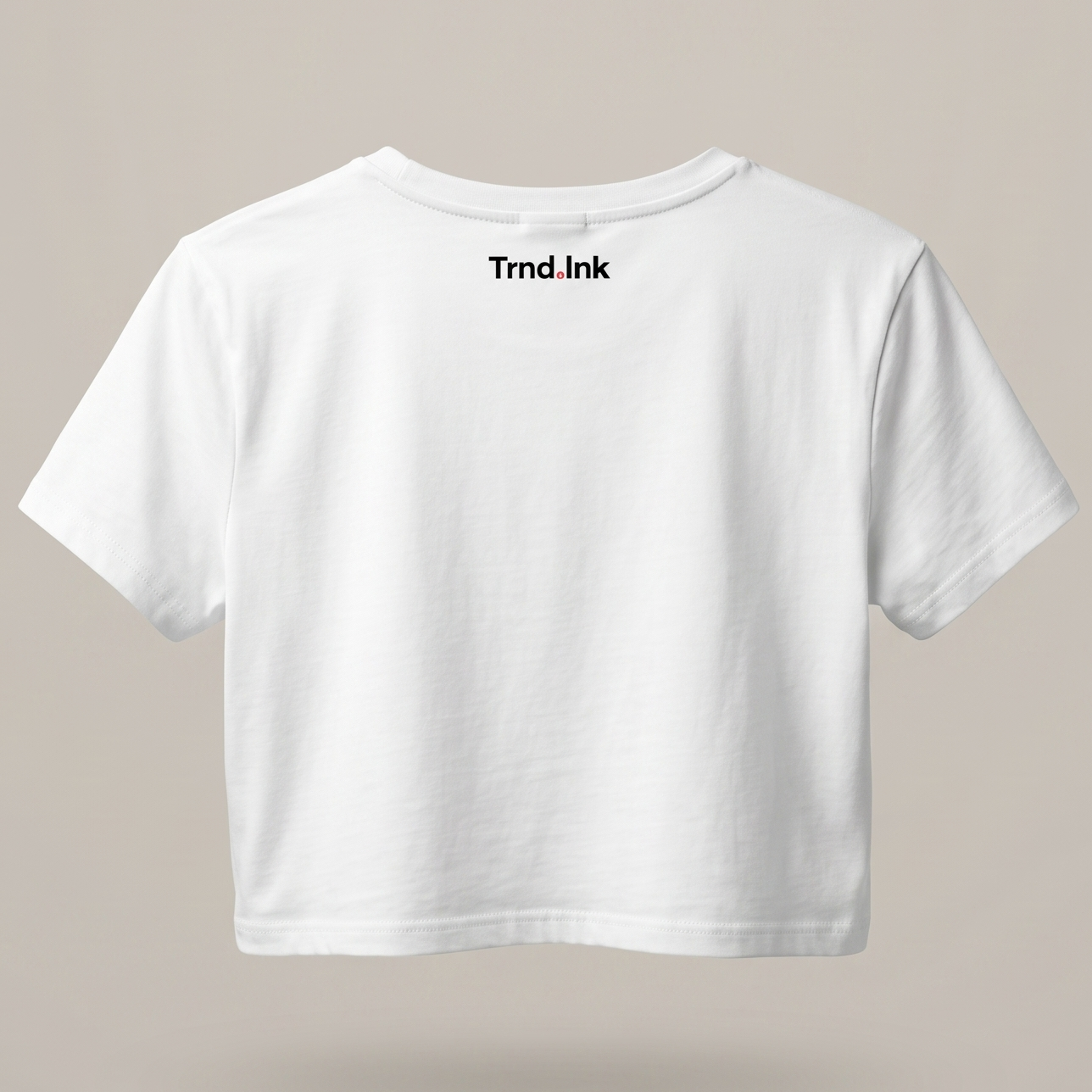 Vista posterior de un crop top blanco para mujer flotando, destacando el logo de Trnd.Ink ubicado en la parte superior central de la espalda