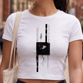 Mujer en la calle usando un crop top blanco con diseño gráfico vertical estilo anime y llevando una bolsa de tela, moda urbana y aesthetic.
