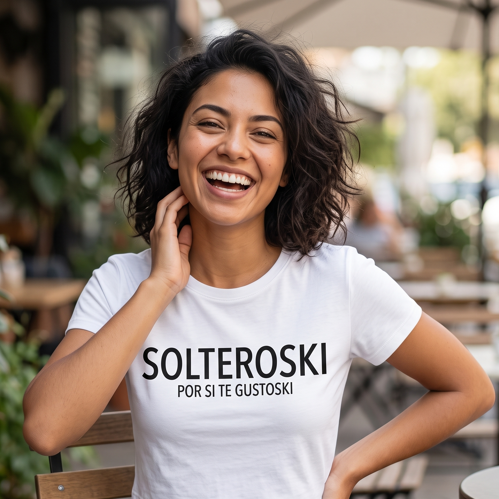 Mujer sonriendo en una terraza vistiendo una camiseta blanca tipo crop top con la frase estampada 'SOLTEROSKI POR SI TE GUSTOSKI' de la marca Trnd.Ink.
