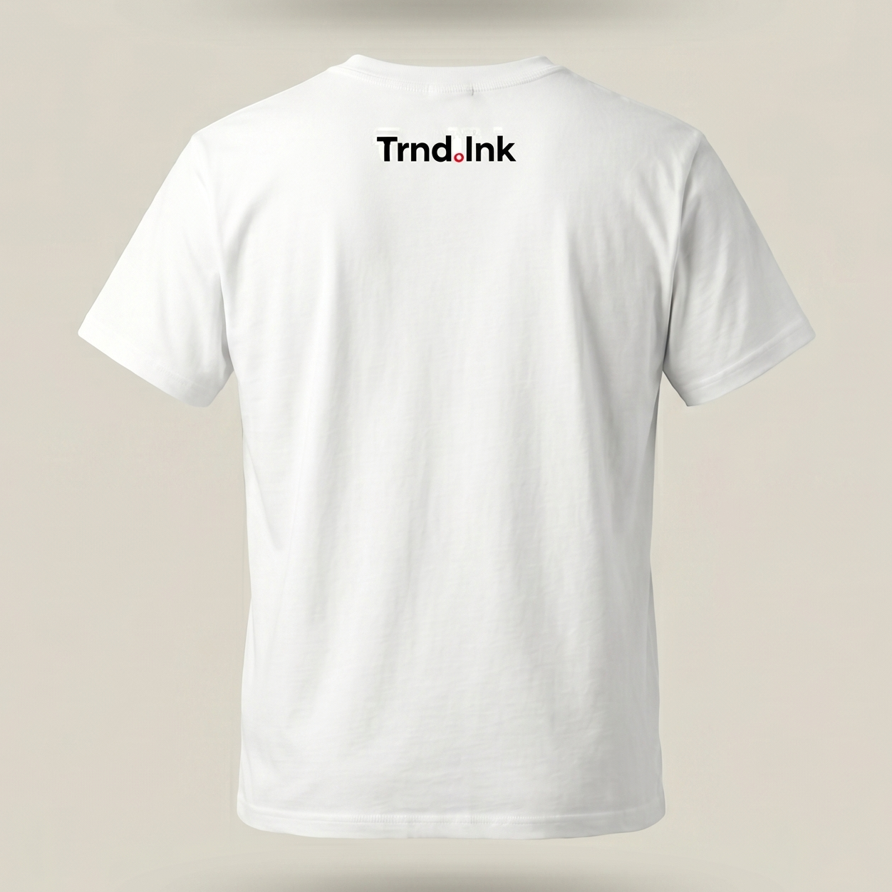 Parte posterior de una camiseta blanca básica de manga corta con el logotipo de Trnd.Ink impreso en la zona superior central de la espalda sobre un fondo liso color crema.