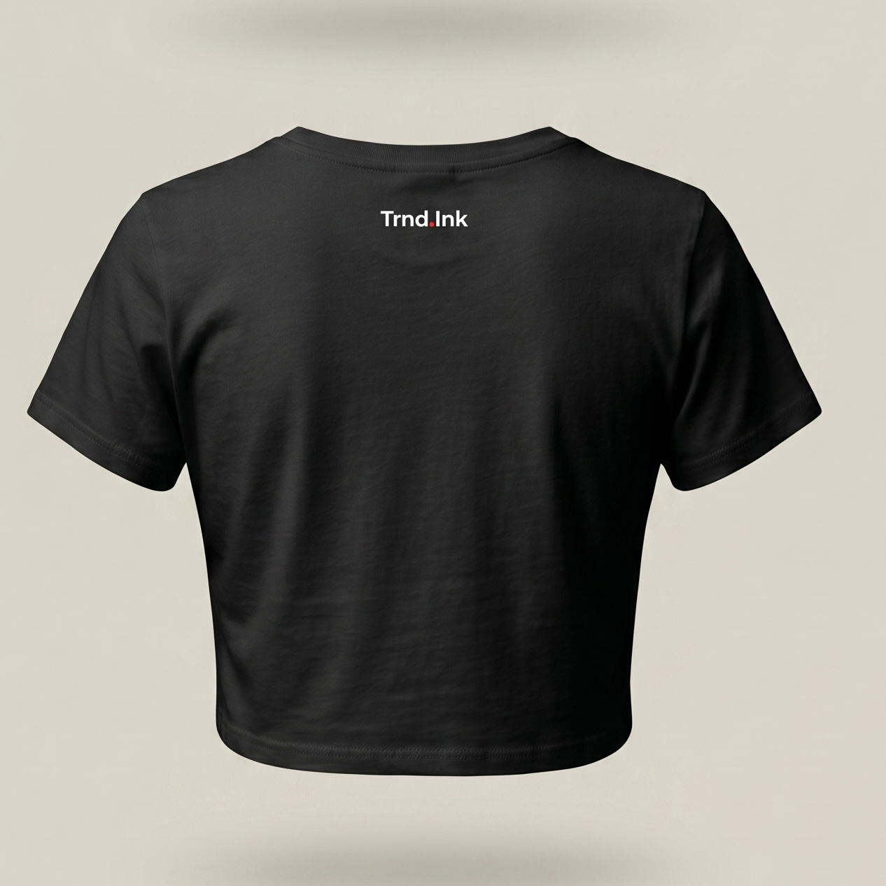 Vista trasera de un crop top de mujer de color negro sin mangas, sobre un fondo neutro y limpio. El logo de la marca Trnd.Ink está estampado en blanco en la parte superior central de la espalda.