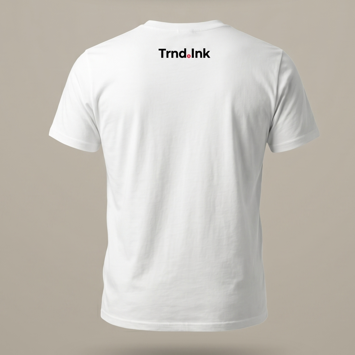 Detalle de la espalda de una camiseta blanca de manga corta, destacando un diseño minimalista con el logo Trnd.Ink estampado debajo del cuello.